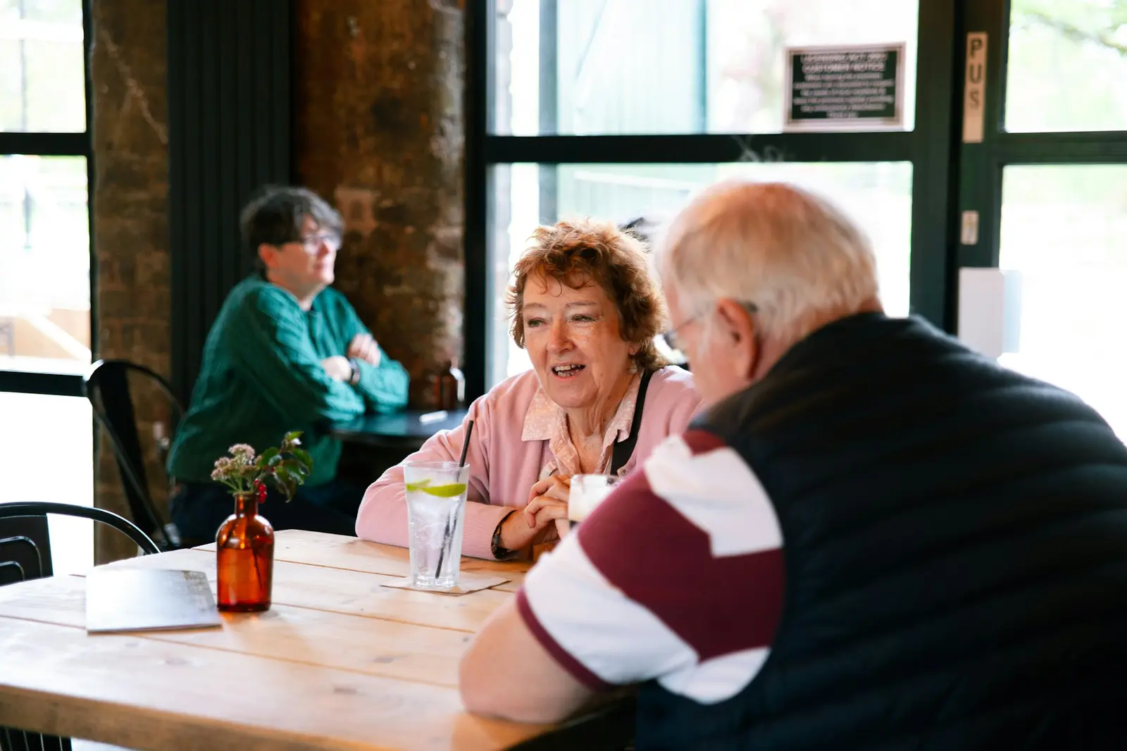 Older friends sharing a lively conversation in a café